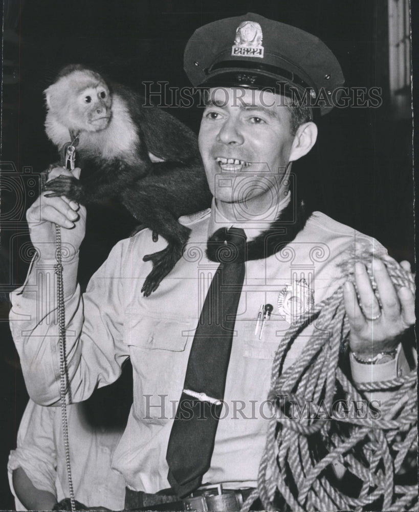 1958 Press Photo Officer Thomas Orlande Captures Escaped Pet Monkey - Historic Images