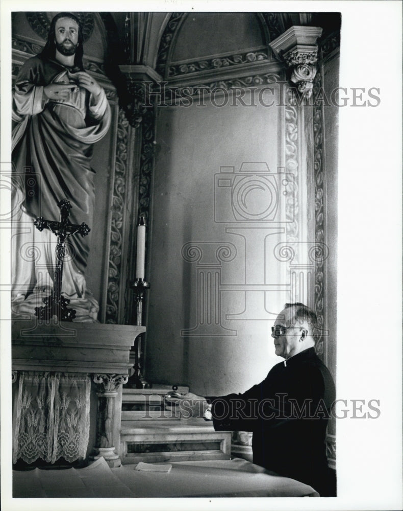 1983 Press Photo Father Philip Laplante places holy water near a statue - Historic Images