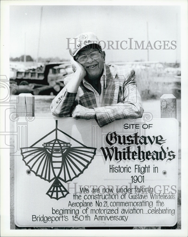 1986William O&#39;Dwyer and sign at hanger of replica plane - Historic Images