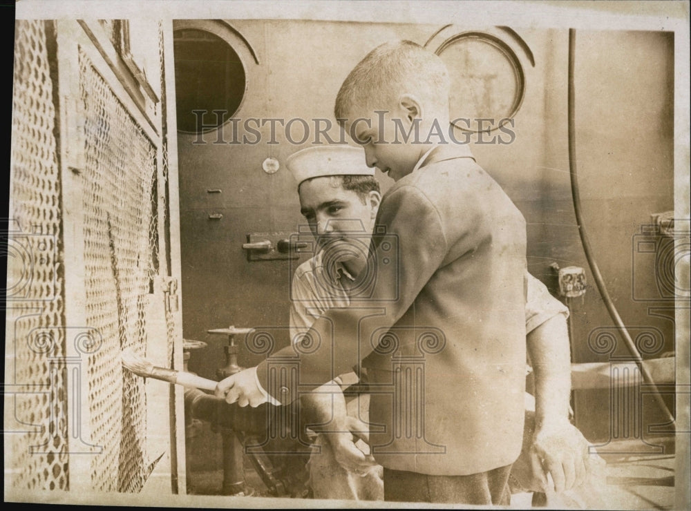 1966 Press Photo Dennis takes a shot at painting,while touring USS Boston - Historic Images