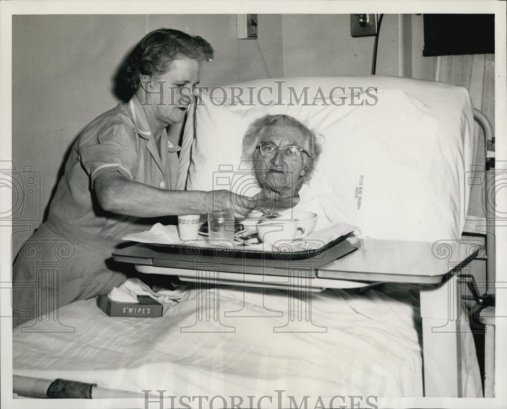 1956 Press Photo Nurse Aide Dorothy Callahan helps Lucy Phillips to eat. - Historic Images