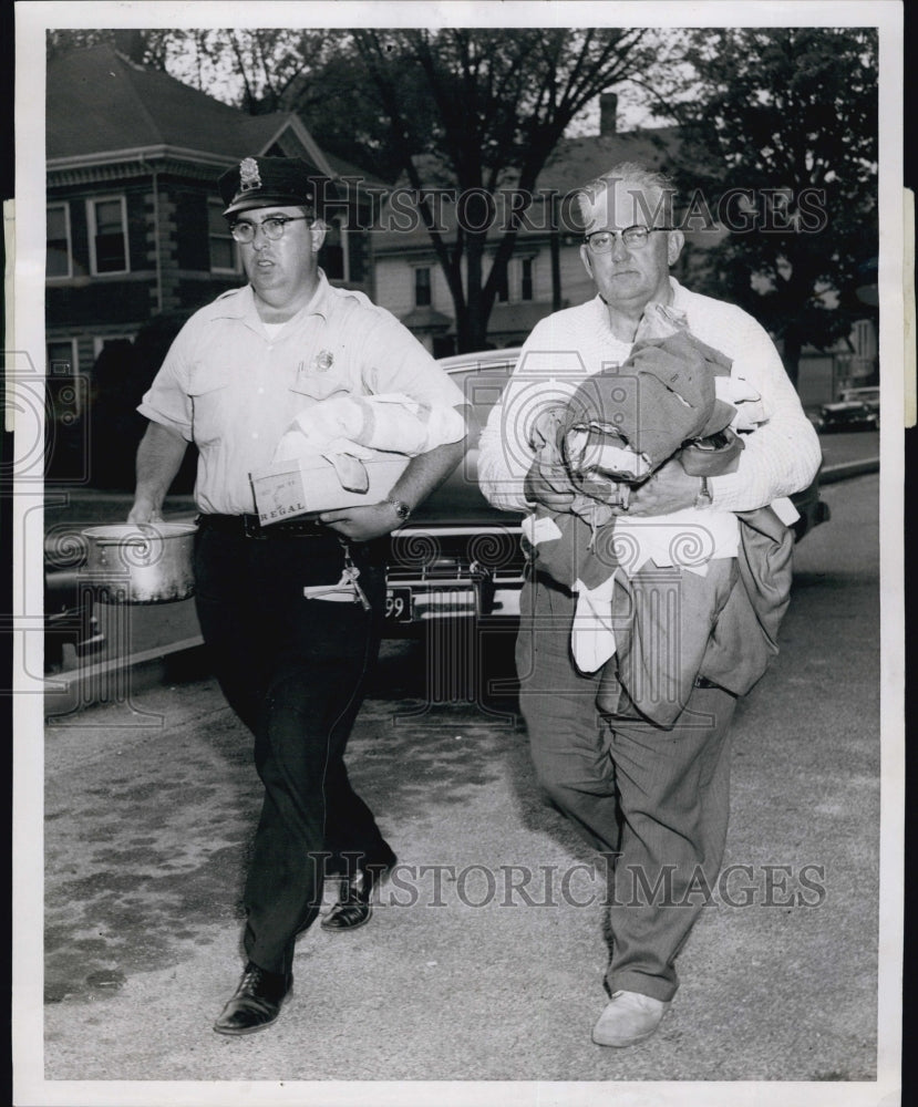 1957 Press Photo Patrolmen carry a suspect&#39;s clothing. Robert Durand. - Historic Images