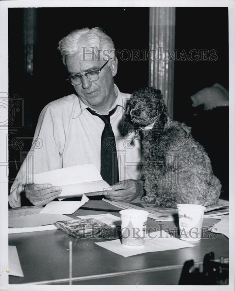 1959 Press Photo C.T. Scanlon at city desk with a Poodle Dog. - Historic Images