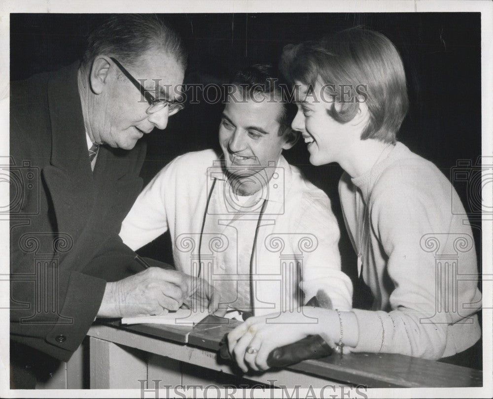 1959 Press Photo Silver Skates Associate Director Frank Melville signs blanks. - Historic Images