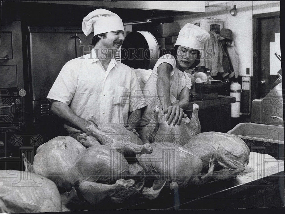 1975 Press Photo M Mirra & S Vietnamese refugee Hung Than Nguyen & turkey prep - Historic Images