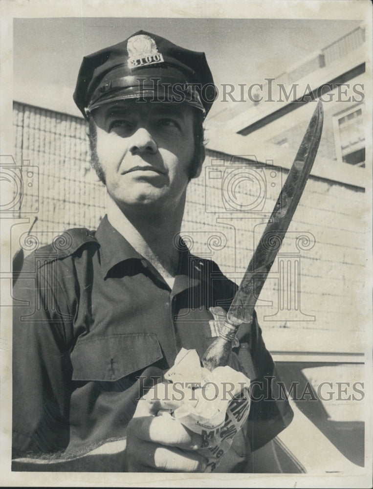 1971 Press Photo Patrolman Tom Maloney with knife used to rob, stab cab driver - Historic Images