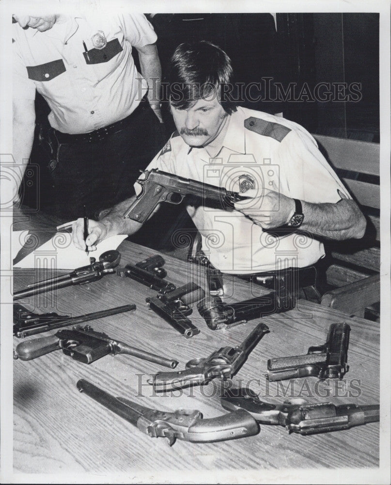 1976 Press Photo  Police officer James Powers &amp; recovered weapons - Historic Images