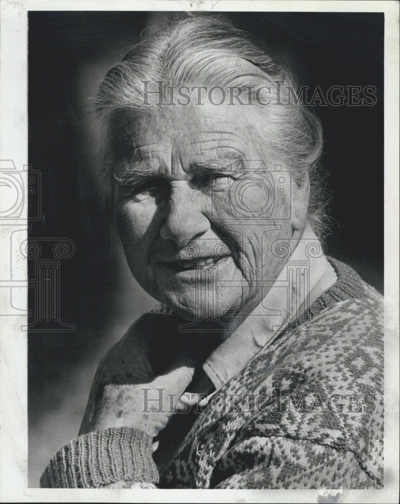 Press Photo An old woman in a sweater sits in the sun - Historic Images