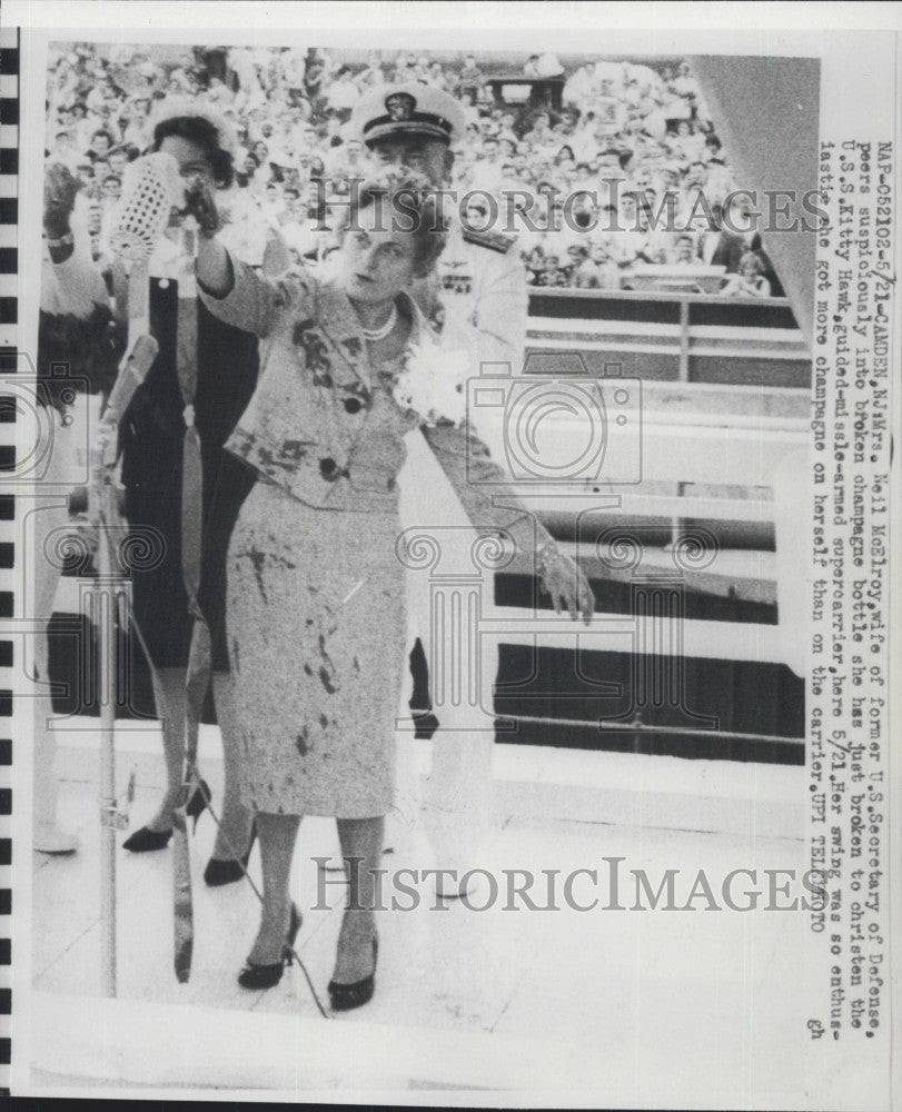 1960 Press Photo Mrs. Neil McElroy, peers suspiciously into broken champagne. - Historic Images