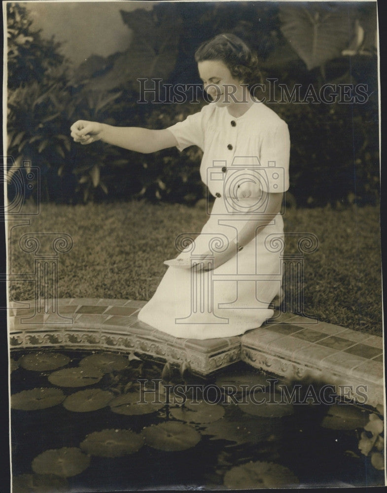 1939 Press Photo A lady at a lily pond with koi fish - Historic Images