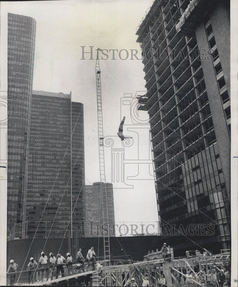 1975 Press Photo Daredevil Bill McGuier Jumps from 100 Foot Tower Amid Flames - Historic Images