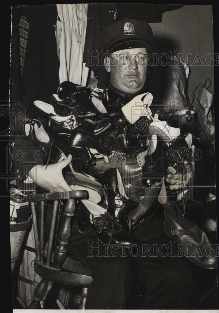 1943 Press Photo Cop William Schultz with shoes from raid on Mrs. Amorse home - Historic Images