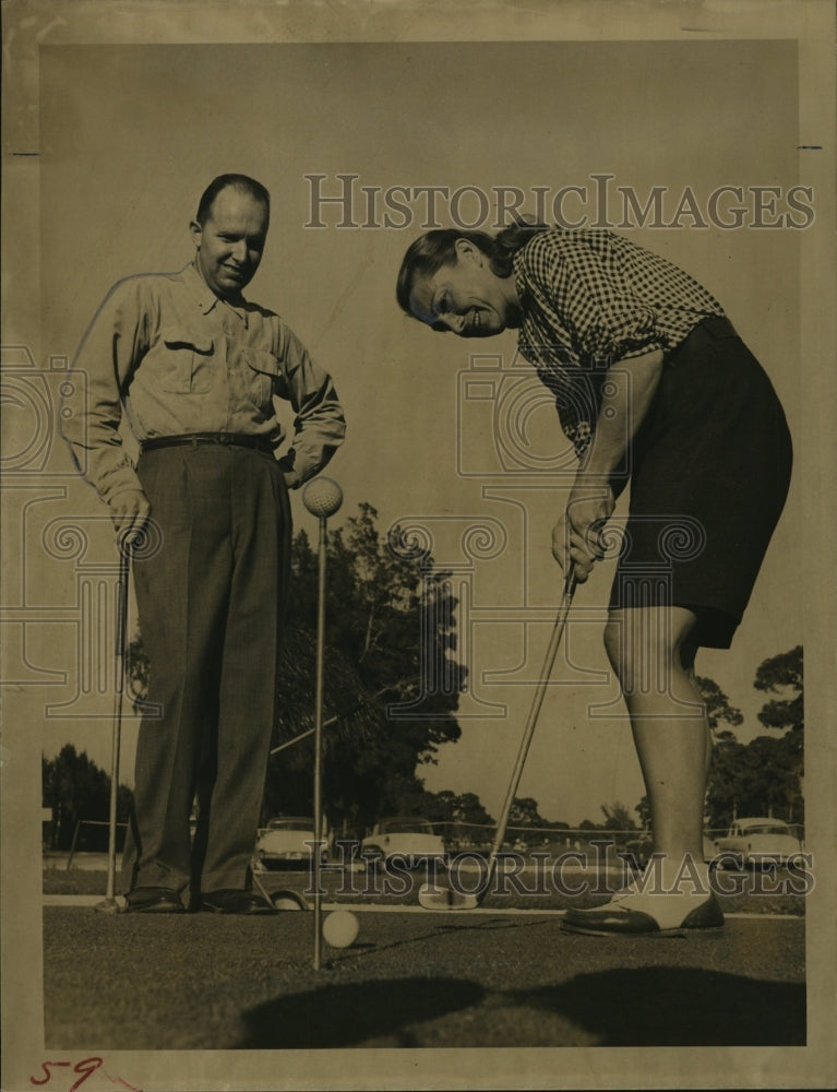 1957 Mrs Walker practices golf as Robert watches - Historic Images