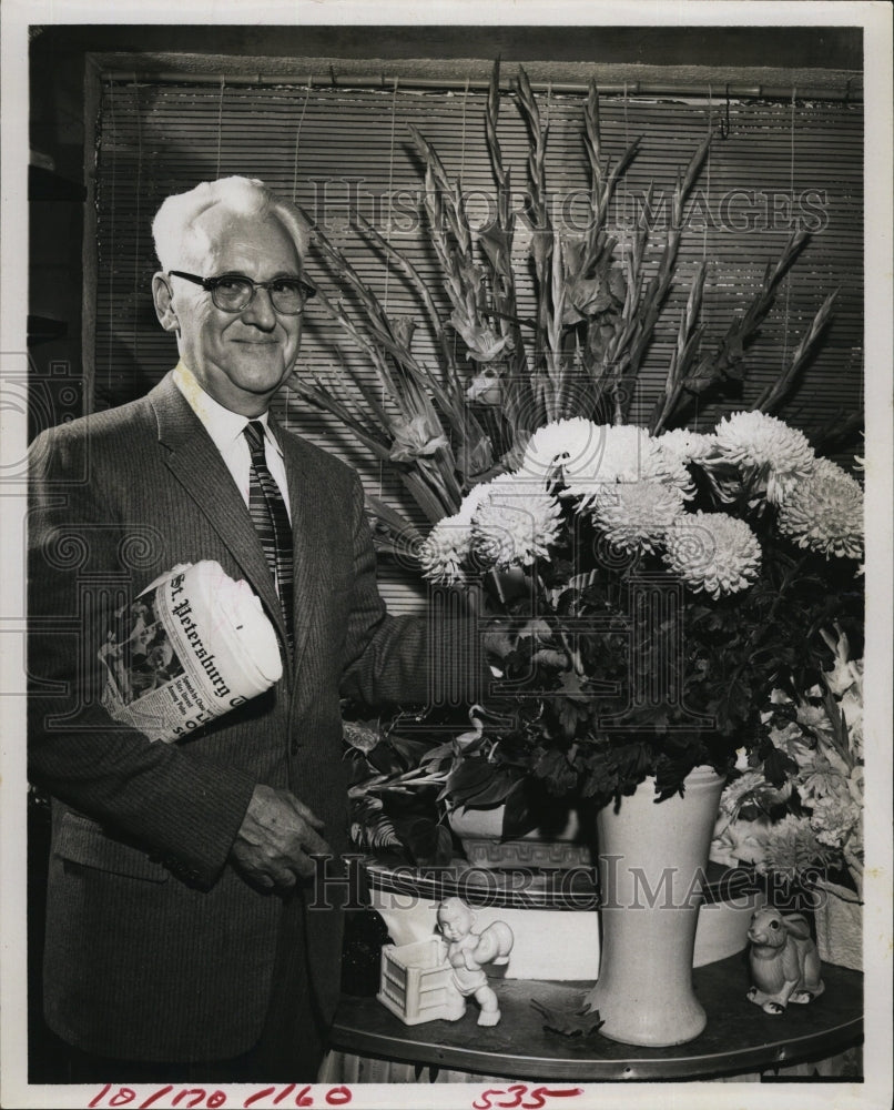 1972 Press Photo H.B. Tinman Standing With Flowers In Vase With Newspaper - Historic Images