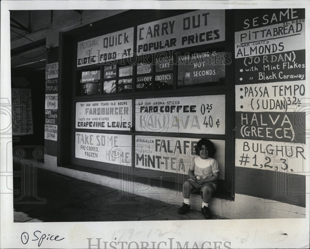 1979 Press Photo Josephine Rabbat, 3, sits in front of her father&#39;s shop - Historic Images