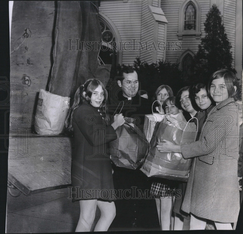 1969 Press Photo Rev. Fr. Daniel Flaherty clothing young parishoners - Historic Images