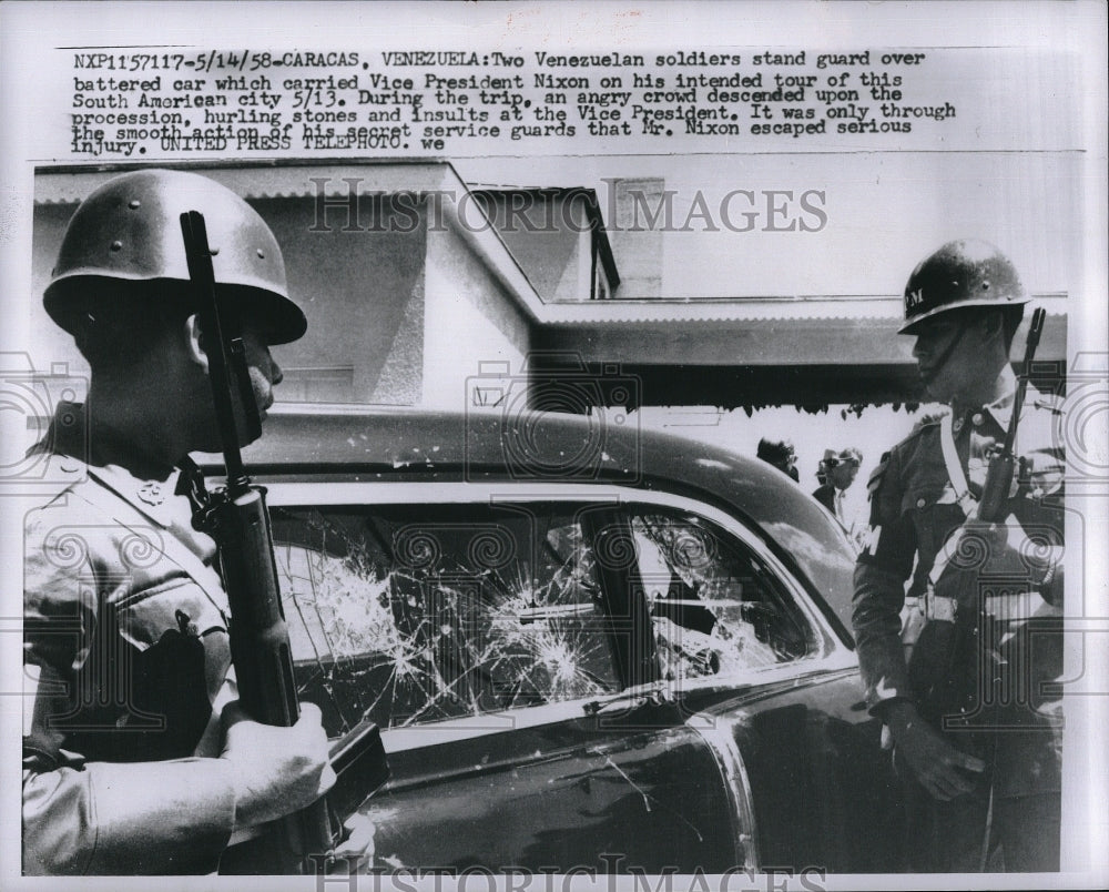 1958 Press Photo Two Venezuelan soldiers stand guard over battered car which - Historic Images