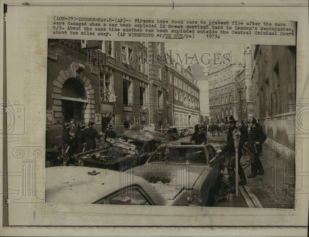 1973 Press Photo Firemen Hose down cars after they were hit by a bomb - Historic Images