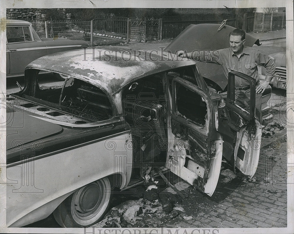 1959 Press Photo Henry Smith ousted MTA foreman standing beside his burned car - Historic Images