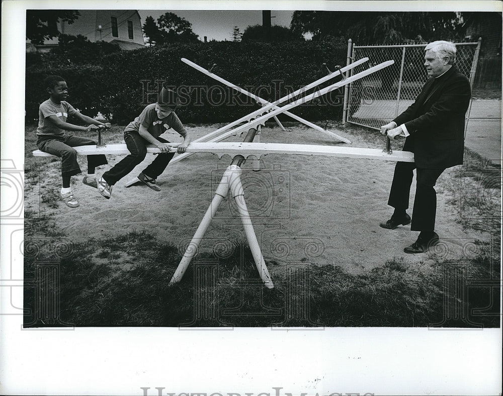 1984 Press Photo Archbishop Law Playing with Campers on See Saw - Historic Images