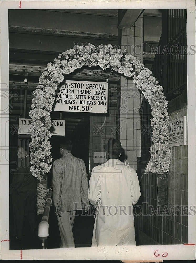 1951 Press Photo Horse Race fans go through wreath of flowers in New York subway - Historic Images