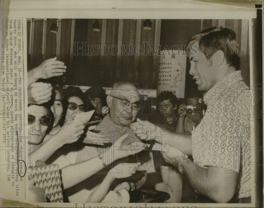 1973 Press Photo Joe &quot;King&quot; Roman hands out photographs of himself - Historic Images