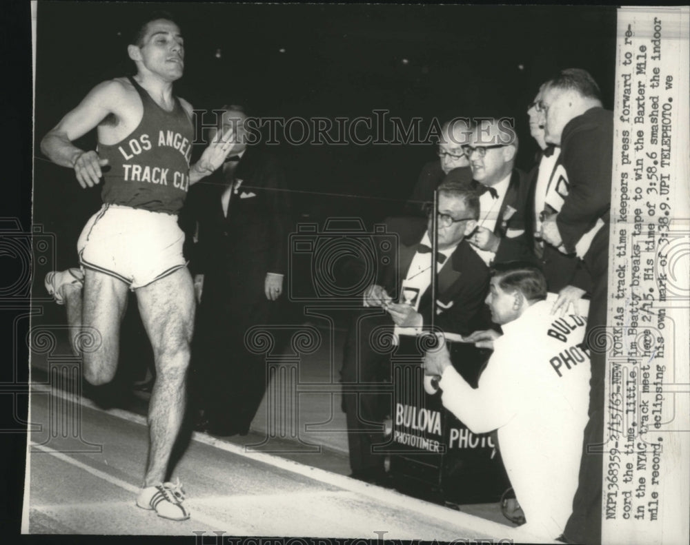 1963 Press Photo Jim Beatty breaks tape to win the Baxter Mile in the NYAC track - Historic Images