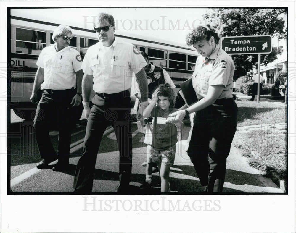 1991 Rescue workers help children from school bus - Historic Images