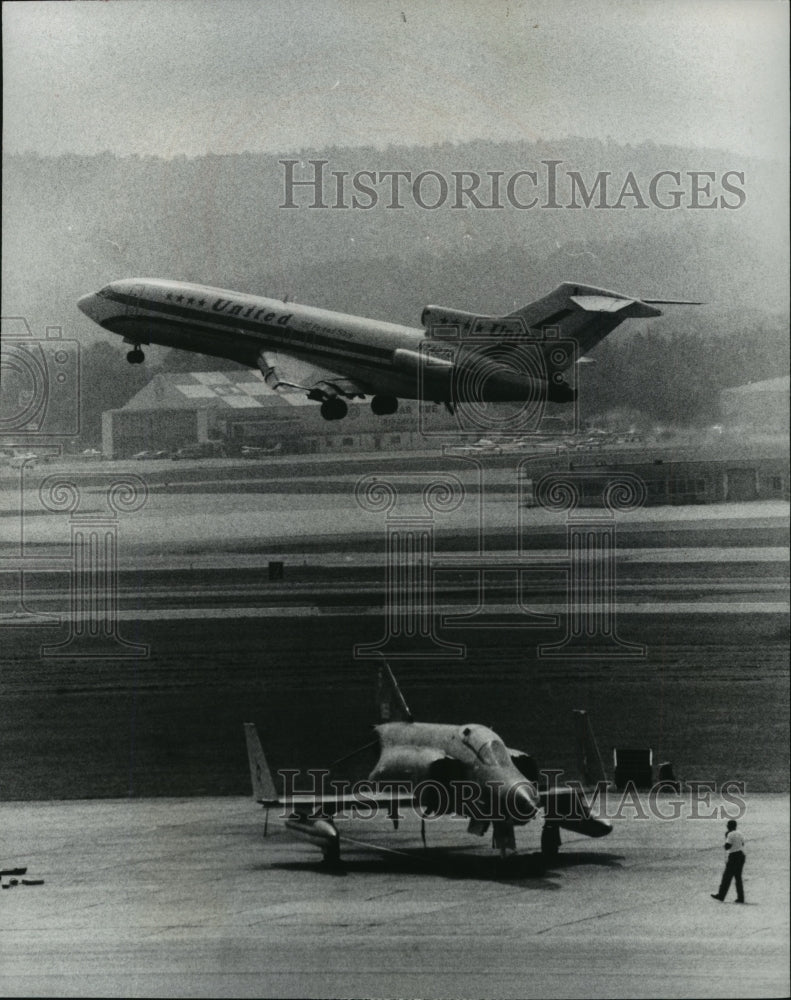 1977 Press Photo Alabama-Commercial jet airborne with military jet in foreground - Historic Images