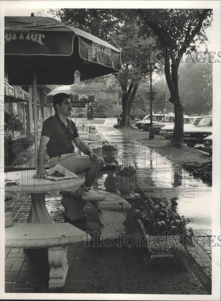 1988 Press Photo Tony Ketabi, Owner of Highland Market, Watches Rain, Birmingham - Historic Images