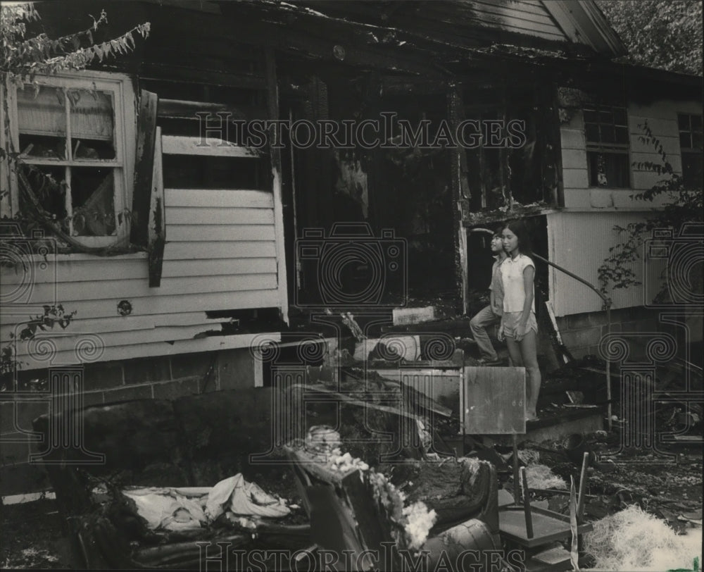 1983 Press Photo Alabama-Vietnamese refugees look over their fire damaged home - Historic Images