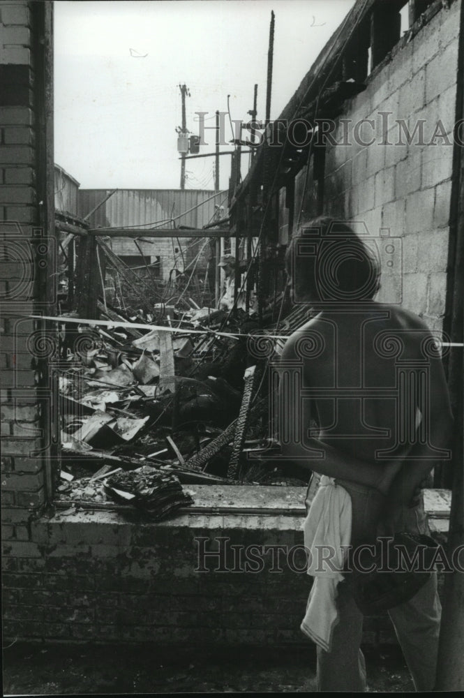 1980 Press Photo Passerby Looks Over Fire Rubble, Jefferson County, Alabama - Historic Images