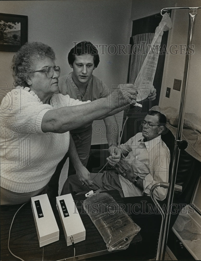 1983 Press Photo Alabama-CAPD nurse shows wife how to use equipment for husband. - Historic Images