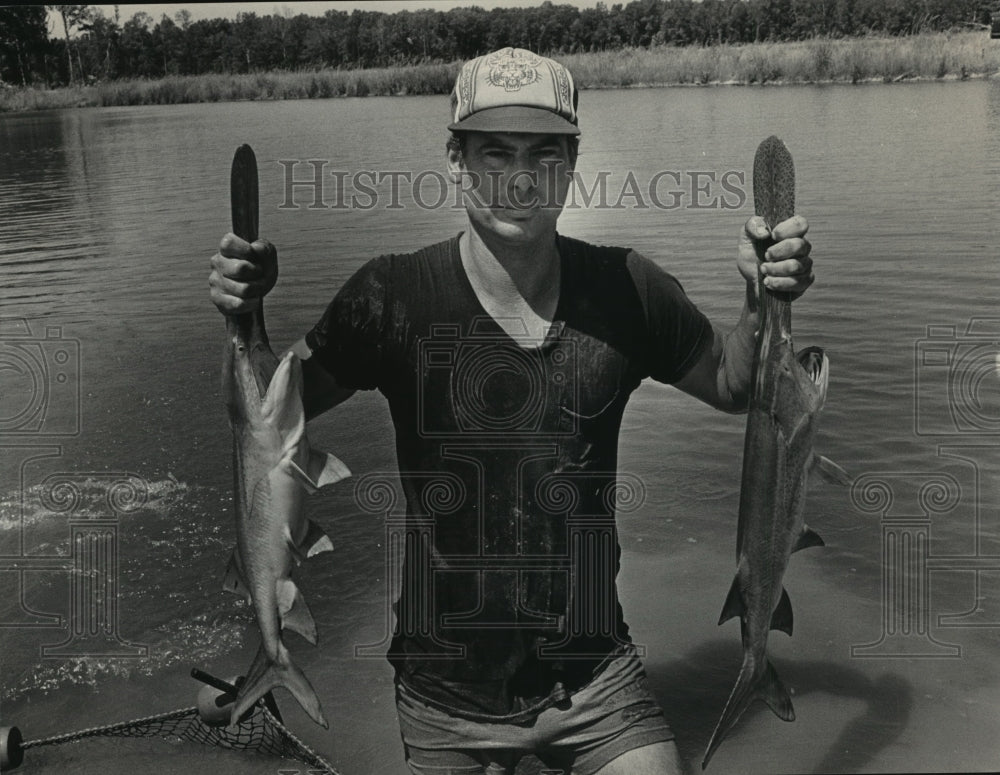 1983 Press Photo Alabama-Butterfield holds two spoonbill fish he is raising. - Historic Images