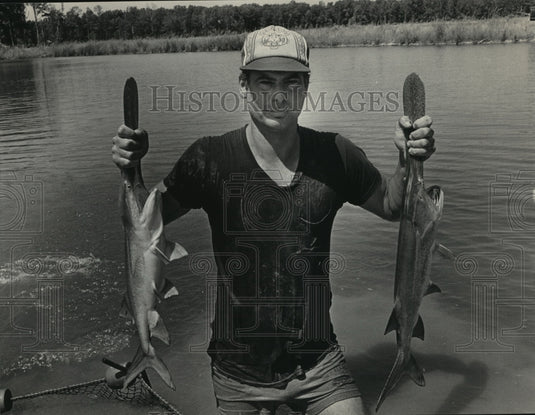 1983 Press Photo Alabama-Butterfield holds two spoonbill fish he is raising. - Historic Images
