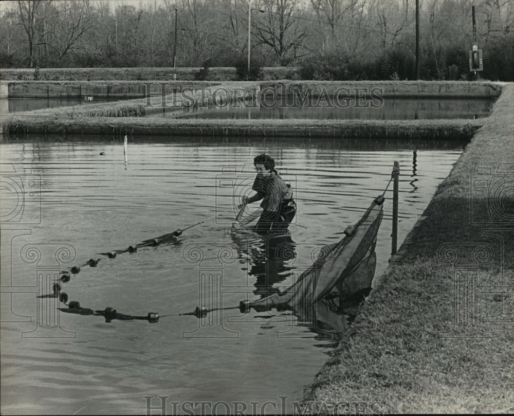 1982 Press Photo Auburn fisheries student Kenneth J. Semmens stocks Opelika Lake - Historic Images