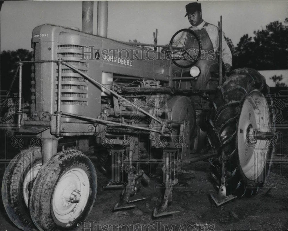 1951, Farm worker sitting on one of two new tractors at this farm. - Historic Images