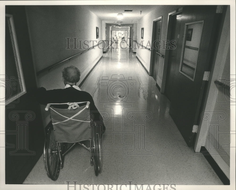 1986 Press Photo Alabama-Elderly man making his way down hall in his wheelchair. - Historic Images