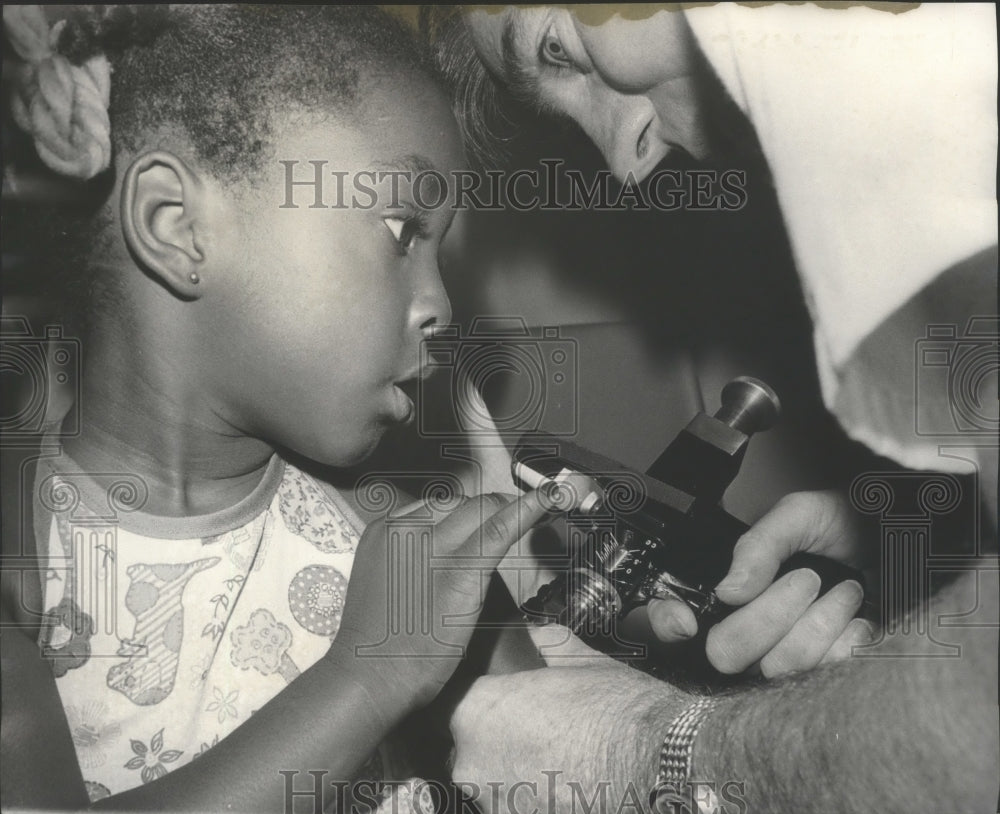 1977 Press Photo Frank Byrd immunizes Tomeka Nelson, Jefferson County, Alabama - Historic Images