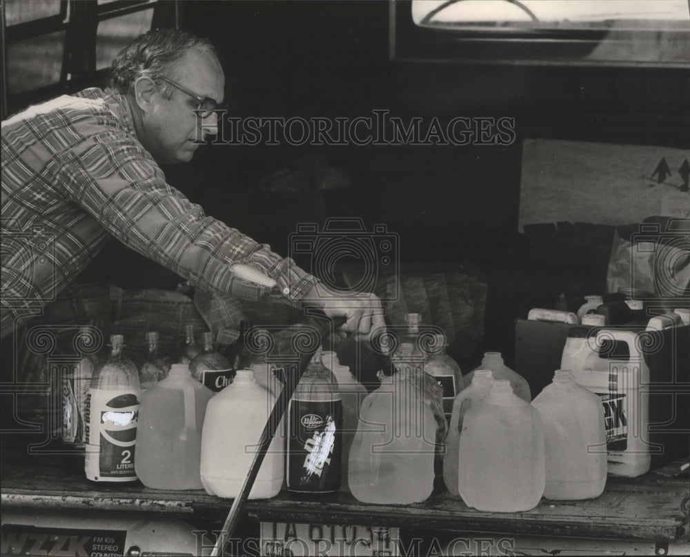 1985 Press Photo Harold Cooper fills jugs with water, Jefferson County, Alabama - Historic Images