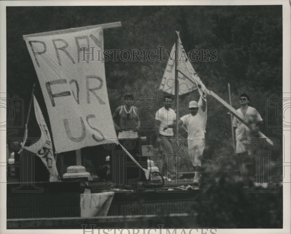 1991 Press Photo Cuban detainees with banner on roof, Talledega, Alabama - Historic Images