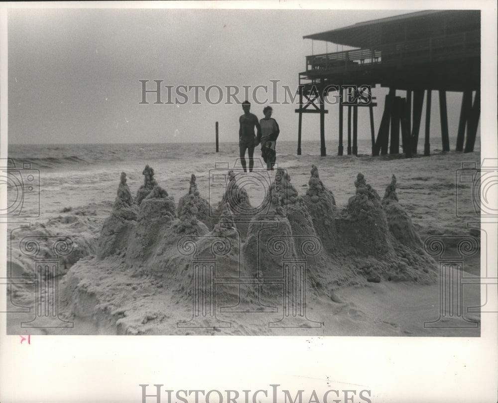 1990 Press Photo sandcastle &amp; couple walk on Orange Beach, Gulf Shores, Alabama - Historic Images