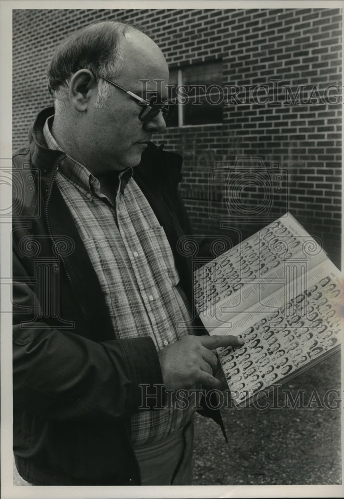 Press Photo Phil Hagle looks through school yearbook at West End Christian - Historic Images