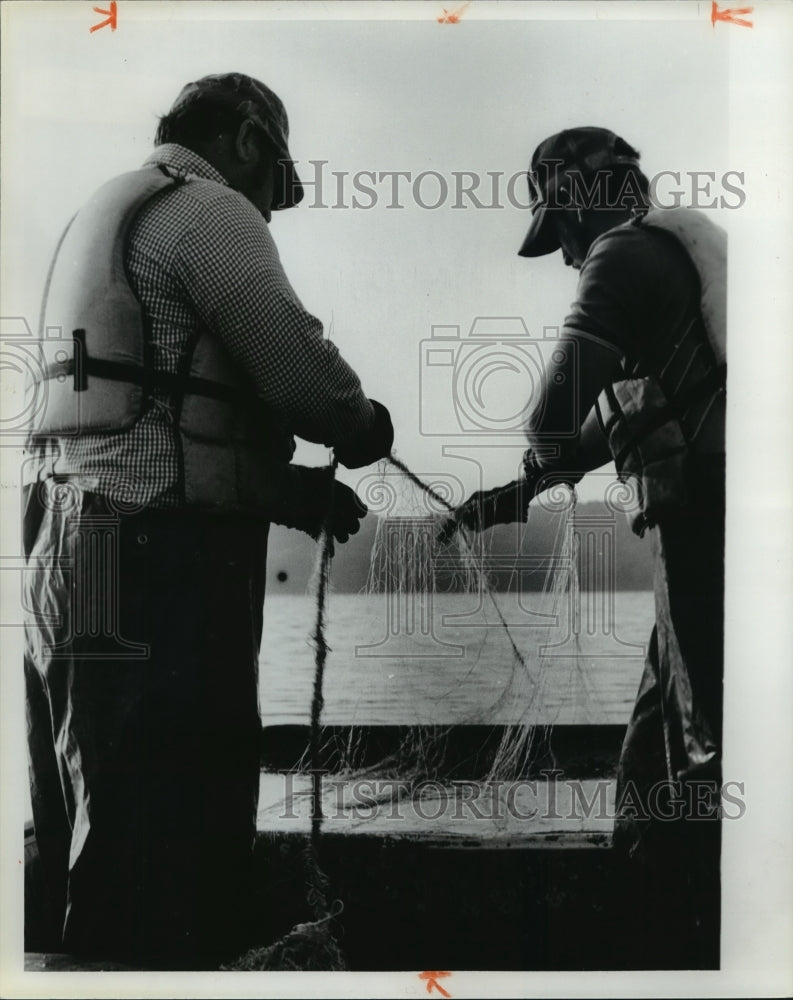 1979 Press Photo Fishermen struggle with tangled fishing net, Alabama - Historic Images