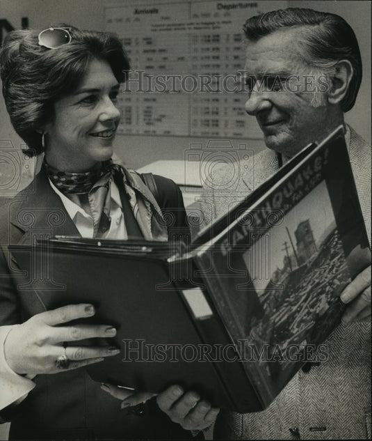 1976 Bloomer and Mrs. Harris Whitbeck read book on earthquakes - Historic Images