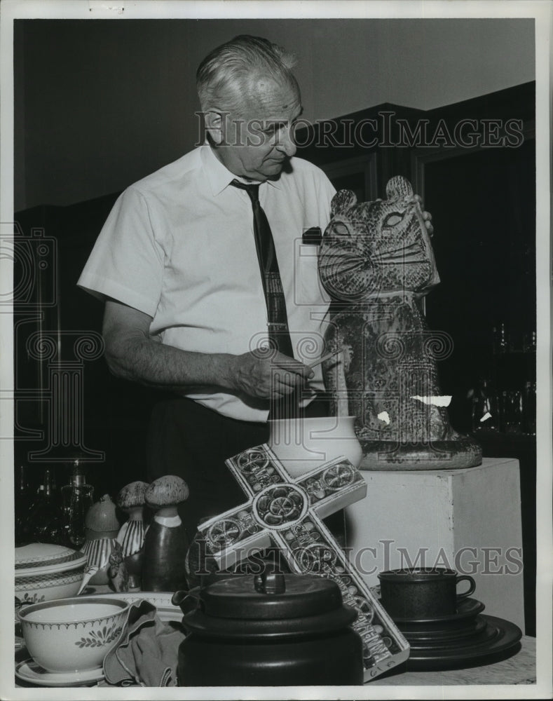 1984, Richard Howard with variety of objects on table - abna14334 - Historic Images