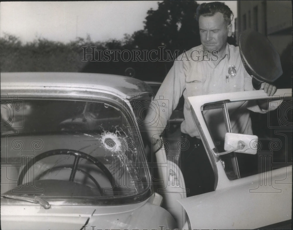 1957 Guntersville Police chief D. R. Morrow inspects windshield - Historic Images