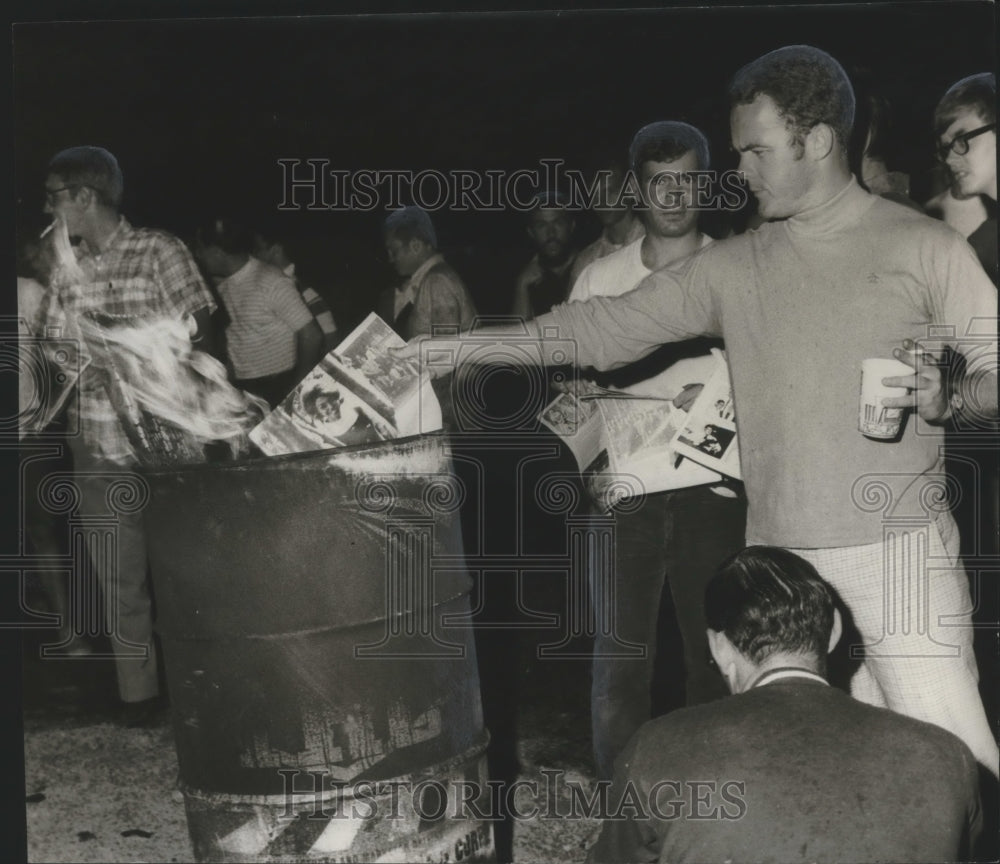 1970 Auburn student tosses Glomerata into bonfire, Demonstration-Historic Images