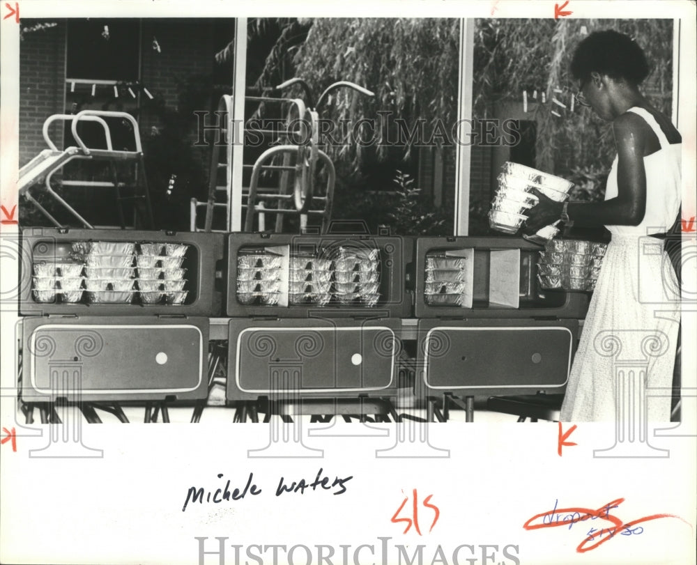 1981, Site manager Michele Waters loads &#39;meals on wheels&#39; in carriers - Historic Images