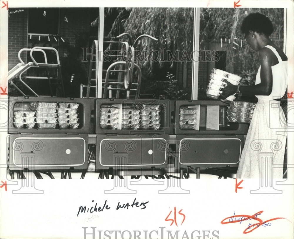 1981, Site manager Michele Waters loads 'meals on wheels' in carriers - Historic Images